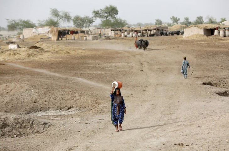 Một người phụ nữ đi lấy nước từ máy bơm bằng tay trong đợt nắng nóng nhất xảy ra ở vùng ngoại ô Jacobabad, Pakistan vào tháng 4/2022 - Ảnh: REUTERS